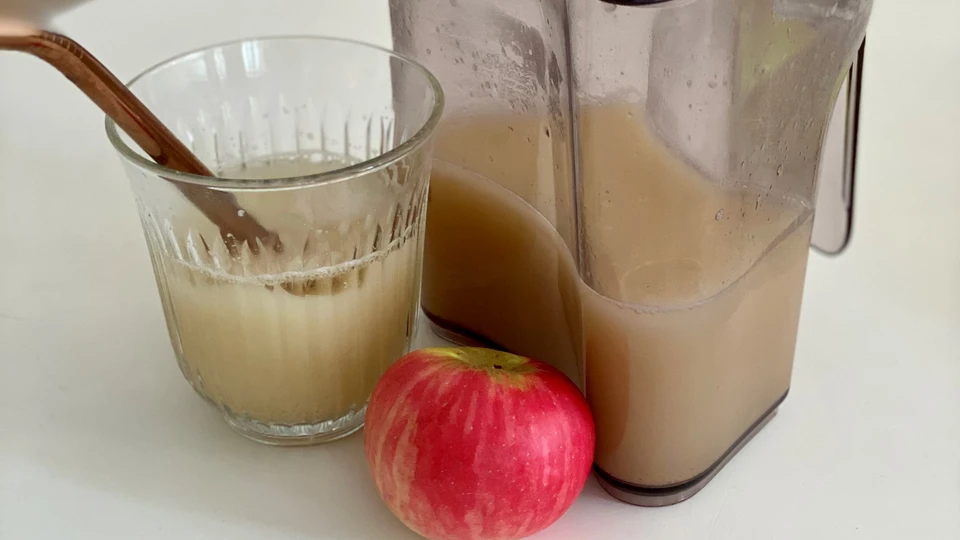 et æble og en kande med æblesaft