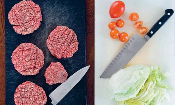 et skærebræt og en kniv med hakket kød - og et andet skærebræt med en anden kniv til salat og tomater
