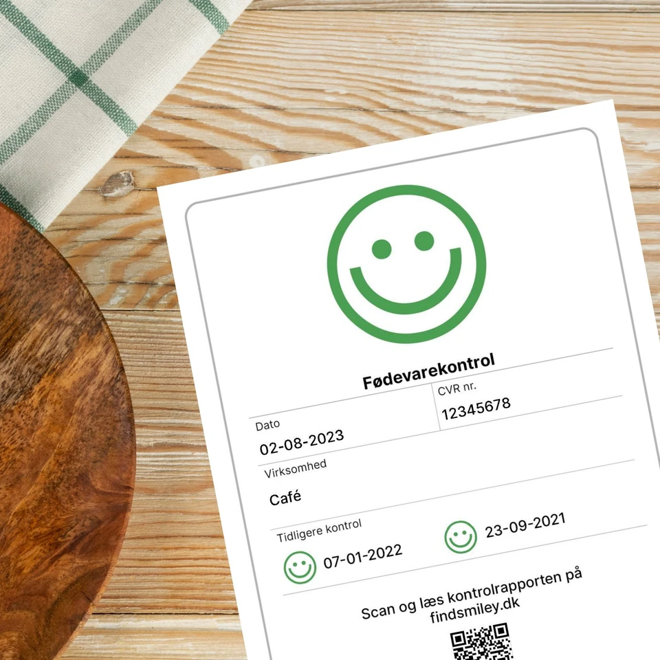 Den nye smileyrapport, som nu skal sidde tydeligt ved indgangen til detailhandelsbutikkerne.