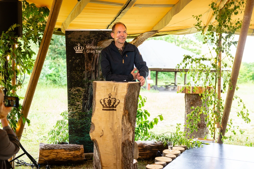 Billedet viser minister for grøn trepart Jeppe Bruus på talerstolen til etårsdagen for den grønne trepartsaftale.