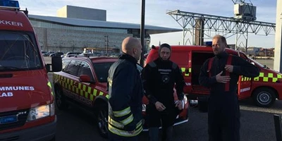 Tre dykkere ved rød Beredskabsbil