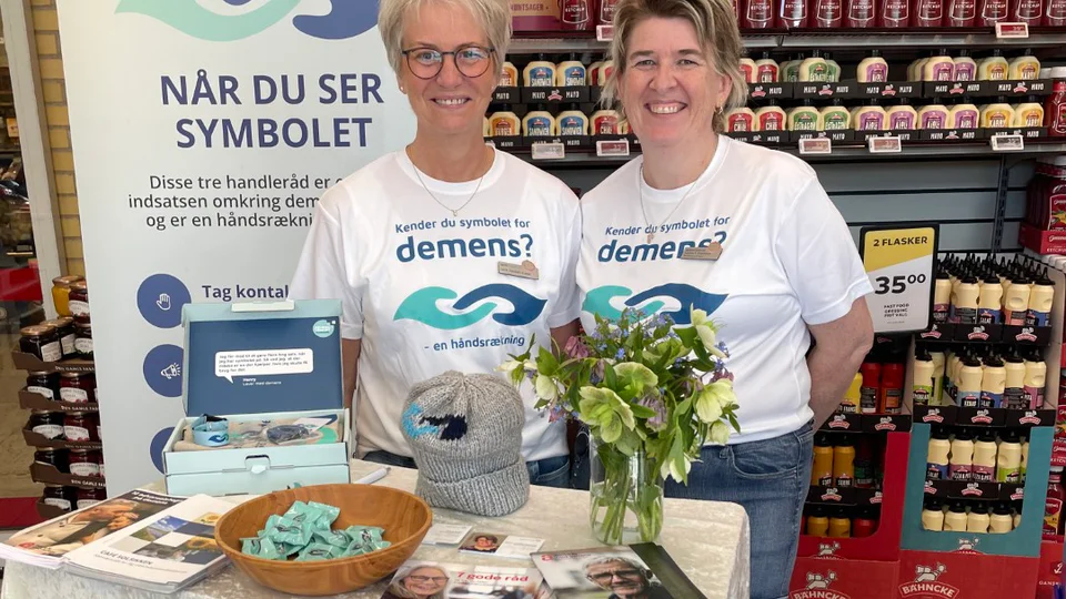 Lene Kudsk og Katrine Eberhardt med en stand i en dagligvareforretning.