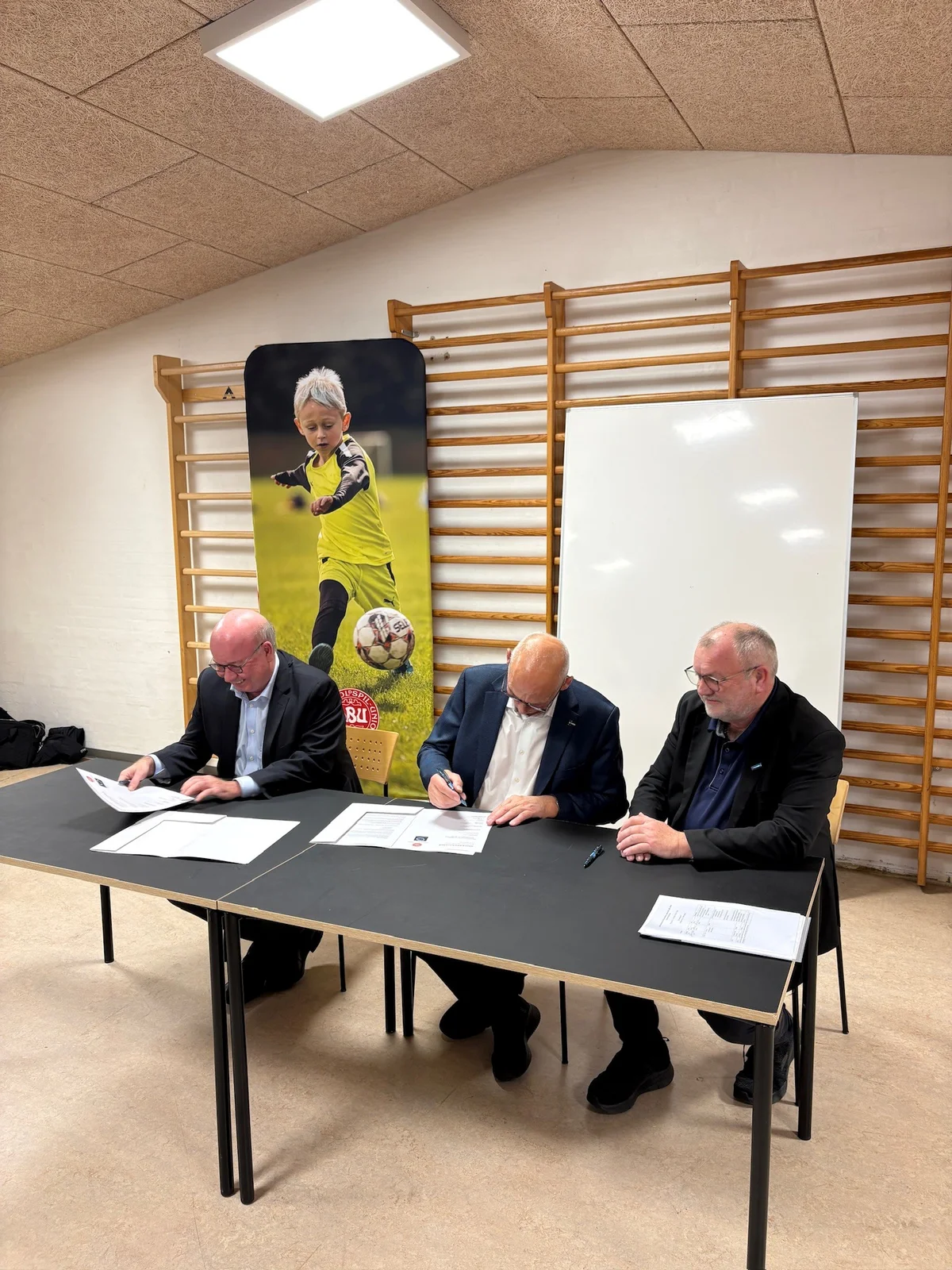Aftalen skrives under af formand for DBU Jesper Møller, borgmester Peder Christian Kirkegaard og formand for DBU Jylland Bent Clausen. Foto: Skive Kommune