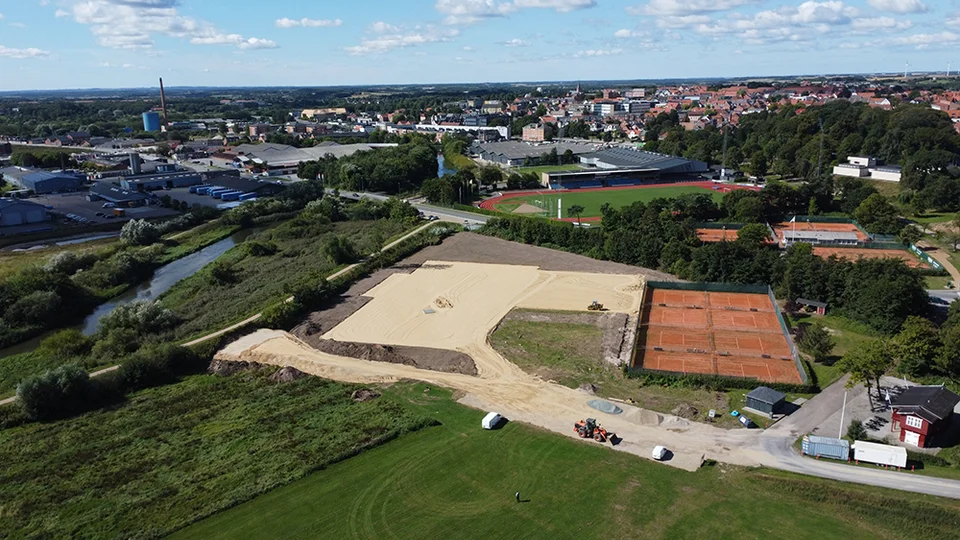 Entreprenørmaskiner er ved at lave bundopbygningen til de nye tennisbaner. August 2022.