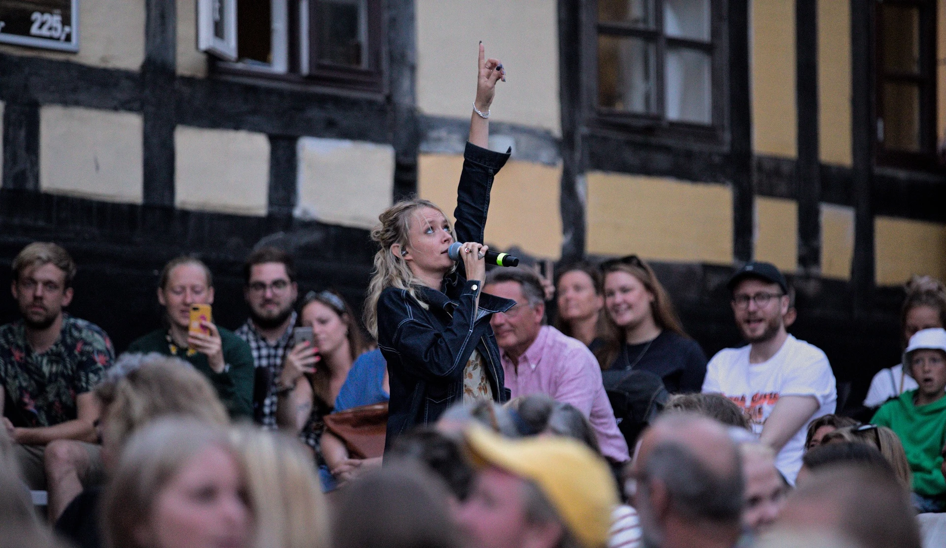 Musiker, Soleima, med mikrofon giver koncert i baggård.
