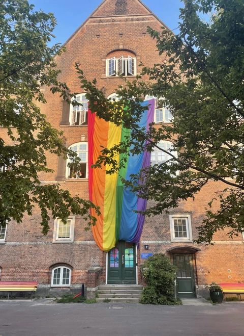 Bygning med et regnbueflag på facaden.