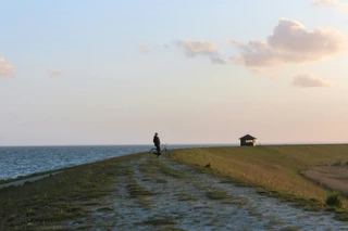 Et menneske på cykel ved stranden
