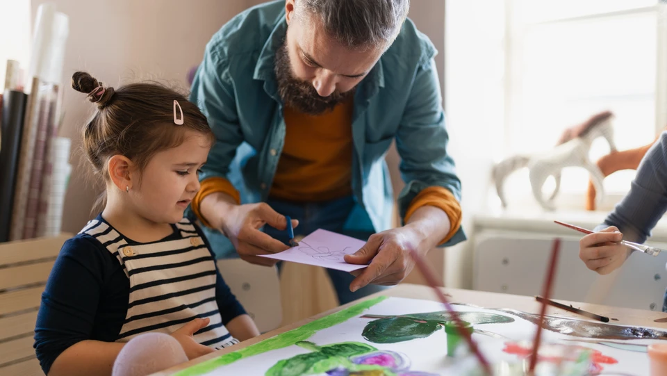 Pædagog laver aktivitet sammen med barn i dagtilbud