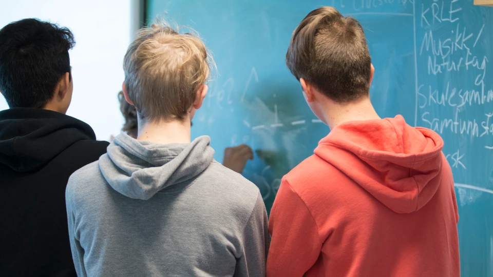 Elever i en gruppe foran en tavle 