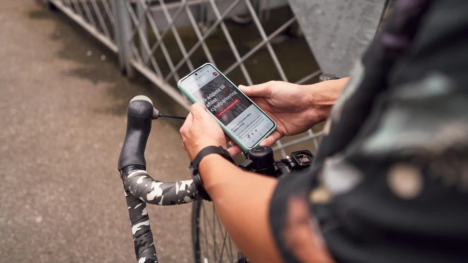 Mand tjekker DSB-app på telefon