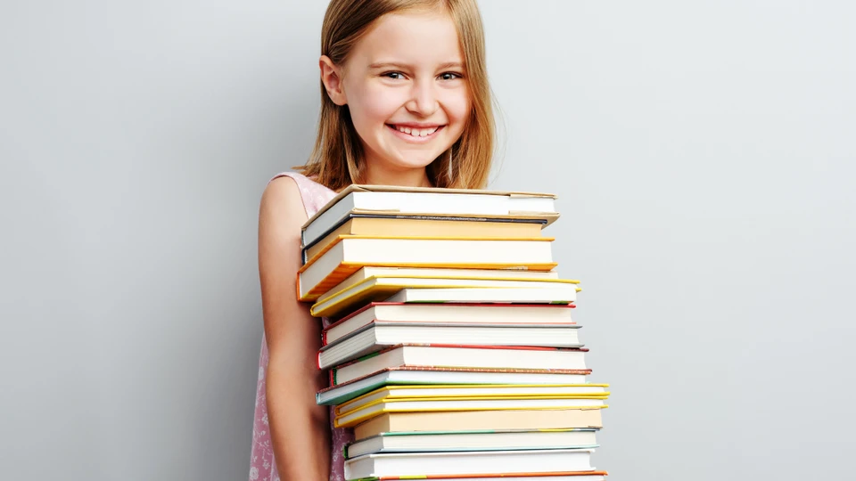 Pige, der holder en bunke bøger