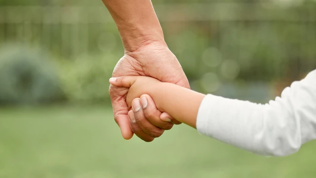 Voksen og barn hånd i hånd