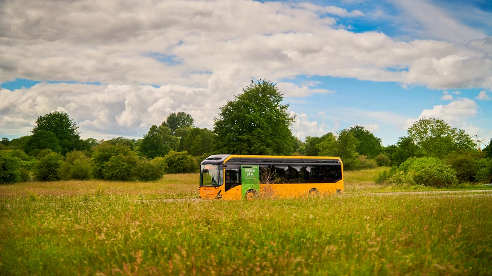 Billede af en Movia Bus der kører igennem landskabet