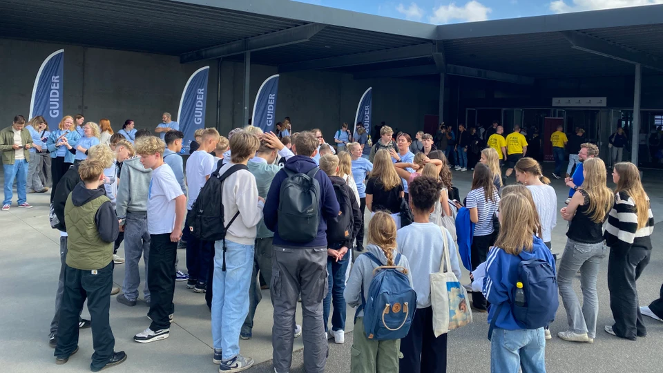 Unge mennesker samlet foran bygning