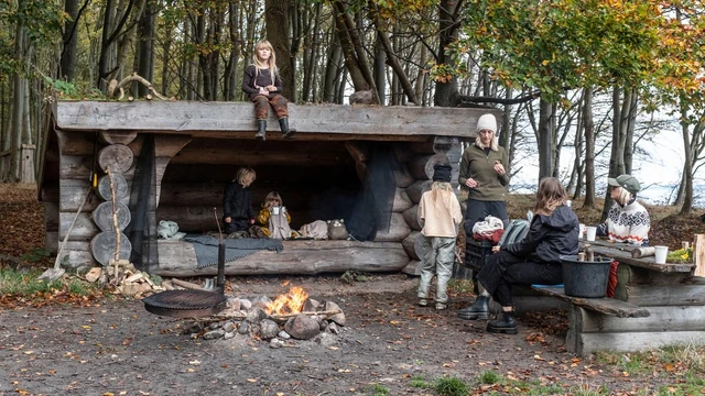 Familie på shelterplads med bål