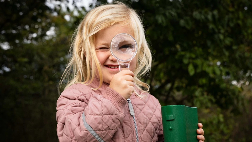 Billede af en børnehave-pige med et forstørrelsesglas
