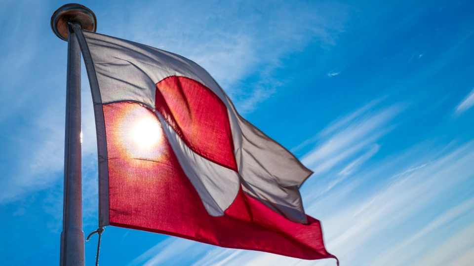 Billede af det grønlandske flag i en flagstand på en solskinsdag