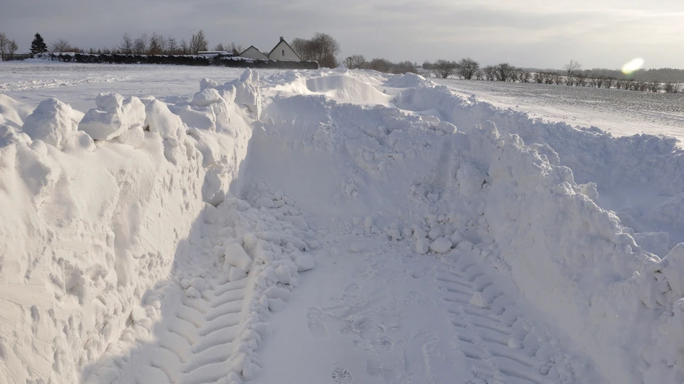 Billede af en vej, der er ved at blive gravet fri af en stor snebunke